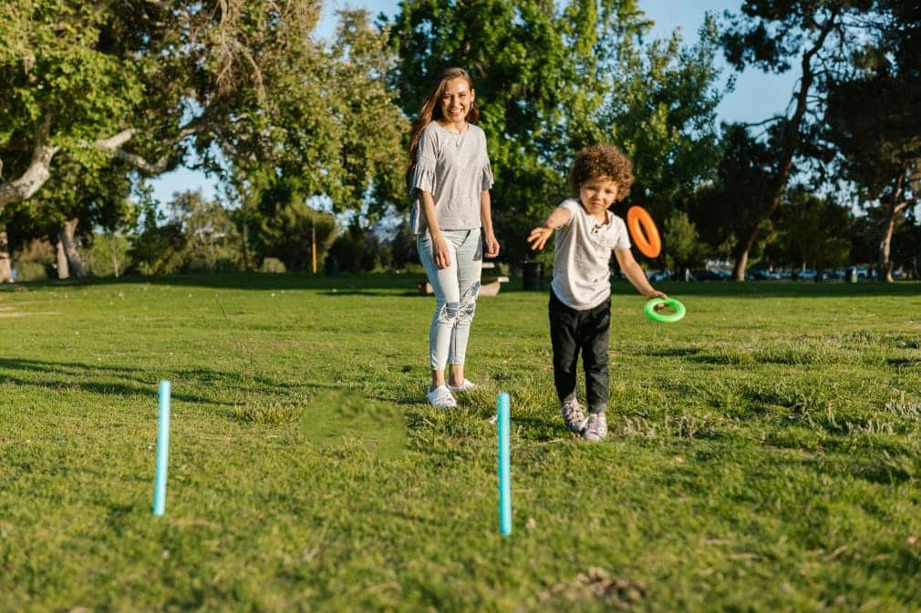 Madre jugando con niño en un parque con cesped - Disfruta de Madrid en Bext Space